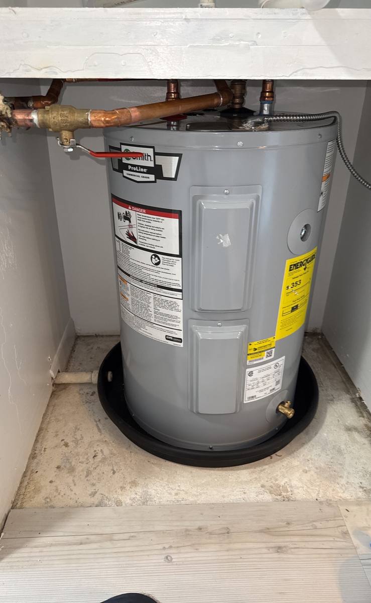 A. O. Smith ProLine water heater installed beneath an air handler with new piping by Blue Wave Home Services