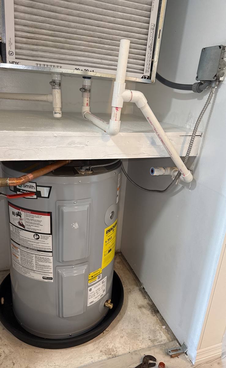 Licensed plumber repairing a water heater in a Palm City, FL home — photo 2