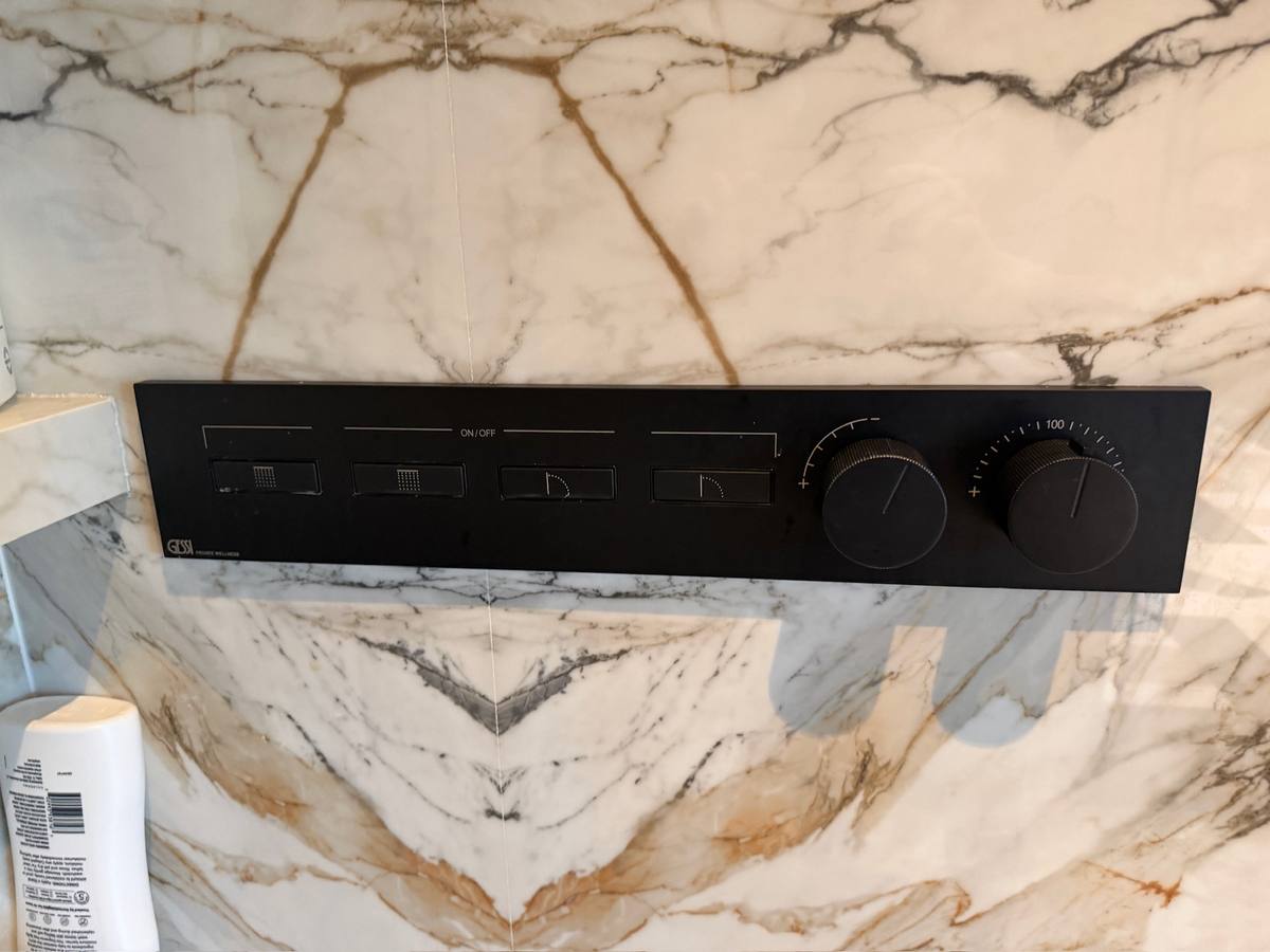 Gessi digital shower control panel installed on a marble wall during a bathroom remodel by Blue Wave Home Services