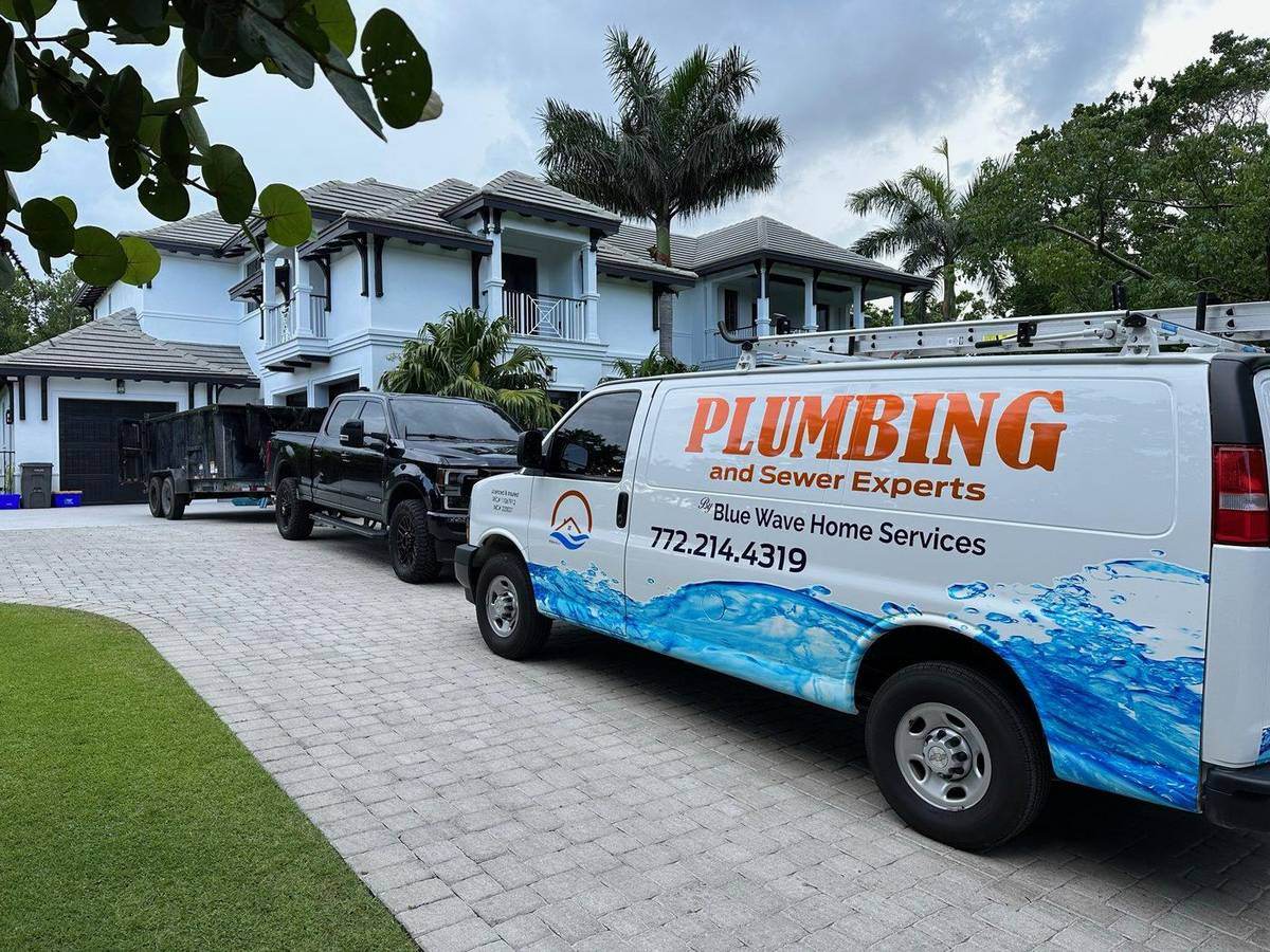 Blue Wave Home Services van in a driveway in front of a modern home
